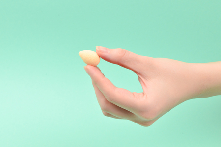 Woman hand holding  beauty sponge  on green background.の写真素材