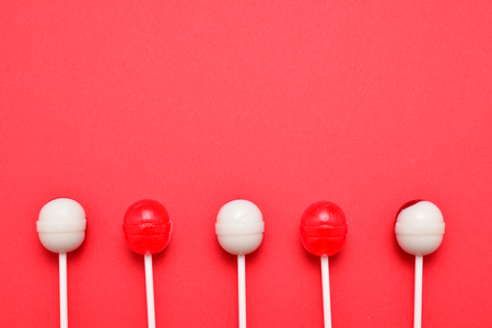 Lollipop on a red background. Space for text or design.の写真素材