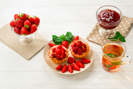 Tea drinking with tartlets and cakes with strawberriesの写真素材