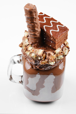 Chocolate extreme milkshake with brownie cake, chocolate paste and sweets. Crazy freakshake food trend. Copy spaceの写真素材