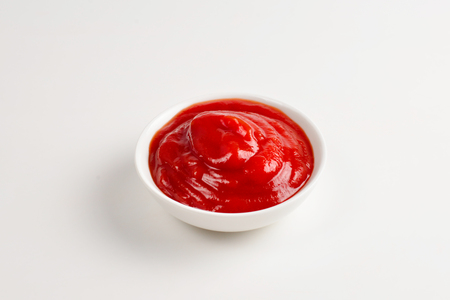 Ketchup in white plate on white background.の写真素材