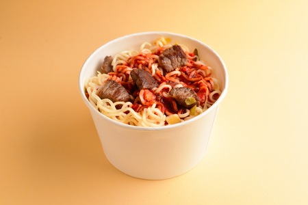 Paper cup with instant ramen noodles with beef and vegetables.の写真素材