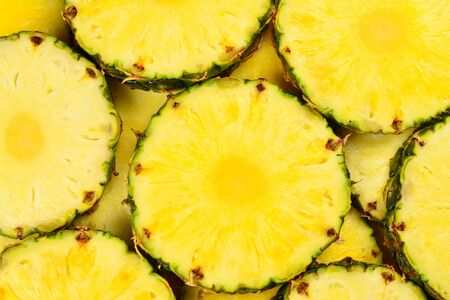 Pineapple juicy yellow slices background. Top view.の写真素材