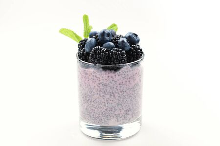 Chia pudding with mint, blueberry, blackberry on a white background. Space for text or design.の写真素材