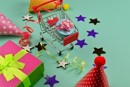 Birthday caps and a present, confetti on a green background. Space for text or design.の写真素材