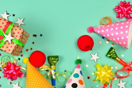 Birthday caps,  present, confetti, ribbons,  stars,  clown noses on a green background. Space for text or design.の写真素材