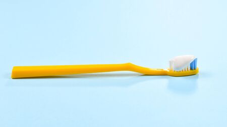 Toothbush with toothpaste on a blue background.