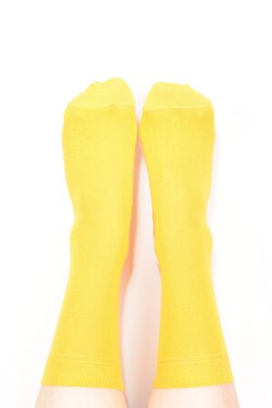 Yellow socks on woman foot isolated on white background.
