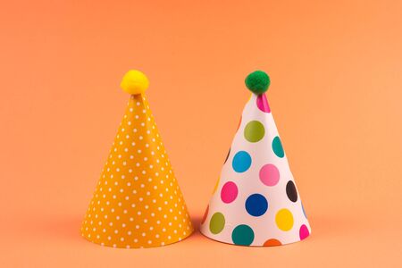 Colorful birthday caps on orange background. Top view.の写真素材