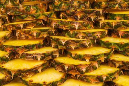 Pineapple juicy yellow slices background. Top view.の写真素材