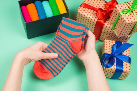 Colorful collection of cotton socks as a gift in woman hands. Gift. の写真素材