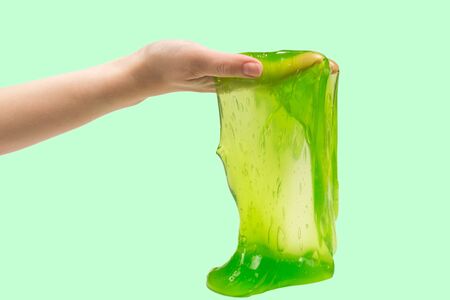 Green slime toy in woman hand isolated on white.の写真素材