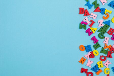 Multicolored letters on a blue background. Top view. Copy space.の写真素材