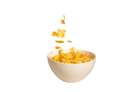 Corn flakes falling to the white bowl. Motion. Copyspace. Isolated on white. の写真素材