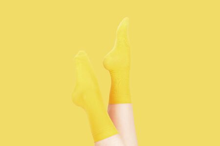 Yellow socks on woman foot isolated on white background.