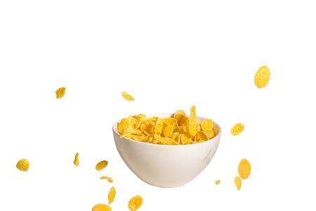 Corn flakes falling to the white bowl. Motion. Copyspace. Isolated on white. 