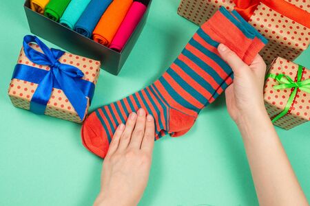 Colorful collection of cotton socks as a gift in woman hands. Gift. 