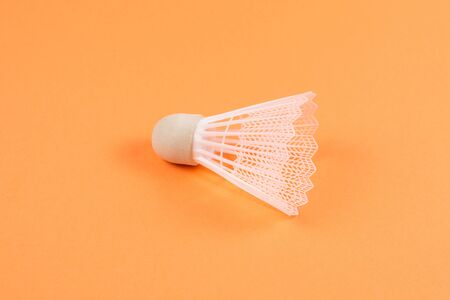 Shuttlecock on orange background. Top view.