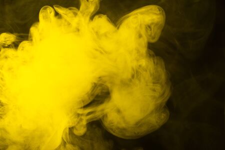 Yellow steam on a black background. Copy space.の写真素材