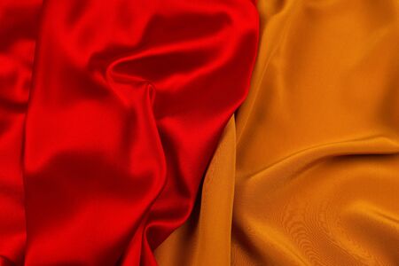 Red and orange silk or satin luxury fabric texture can use as abstract background. Top view.の写真素材