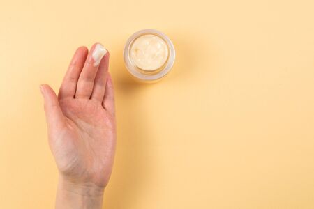 Hand cream and woman hands on a beige background. Copy space.の写真素材