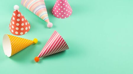 Colorful birthday caps on mint background. Top view.の写真素材