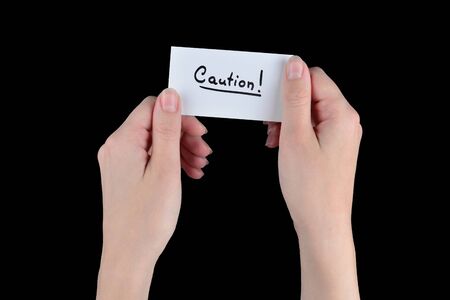 Caution text on a card in woman  on a black background.の写真素材