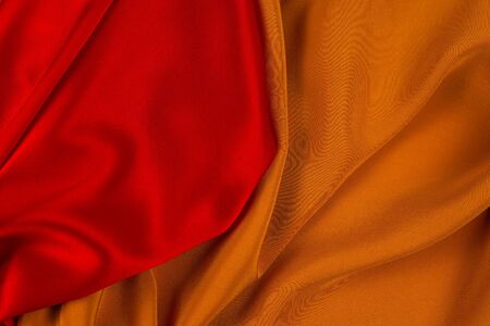 Red and orange silk or satin luxury fabric texture can use as abstract background. Top view.の写真素材