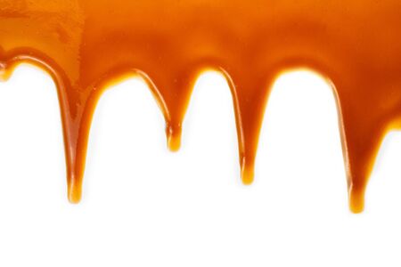 Background of flowing caramel sauce isolated on white. Copy space.の写真素材