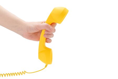 Yellow handset in woman hand isolated on white. Copy space.