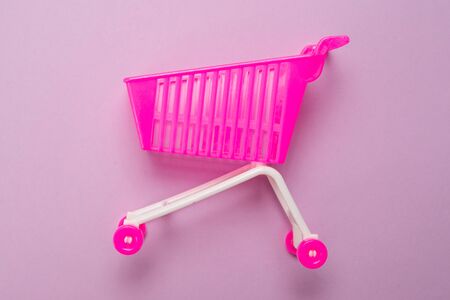 Blue present box with pink bow in a shopping cart on a pink background. の写真素材