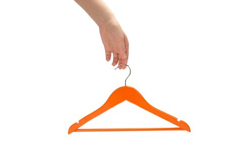 Orange hanger in woman hand isolated on white background.の写真素材