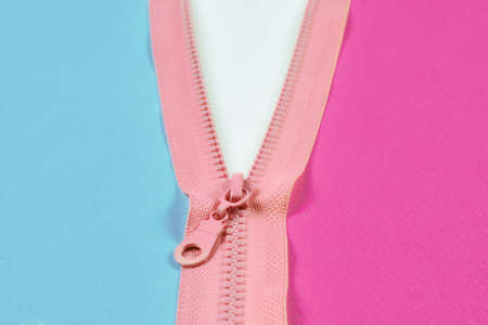 Pink zipper splits green and purple background isolated. Copy space.の写真素材