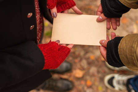 Couple holding an empty vintage sheet of paper in their hands.