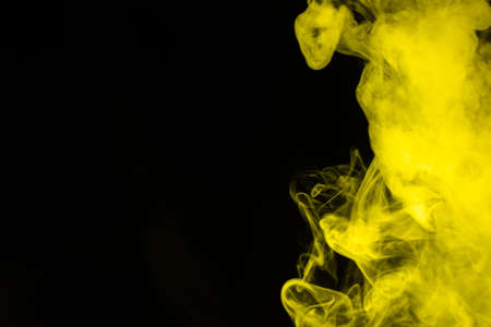 Yellow steam on a black background. Copy space.の写真素材