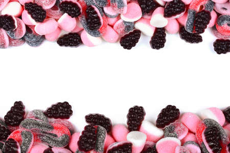 Frame of assorted gummy candies isolated on white. Top view. Space for text or design.