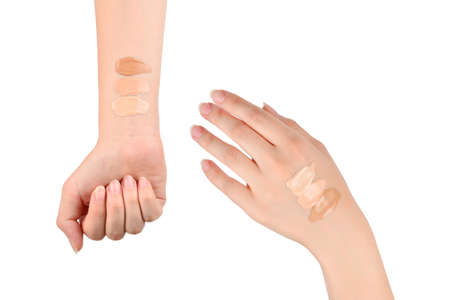Fair, medium, dark swatches of foundation on the hand isolated on white.