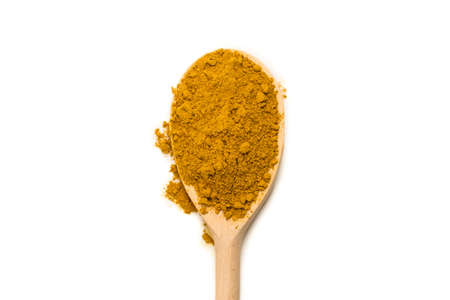 Curry in wooden spoon isolated on white background.