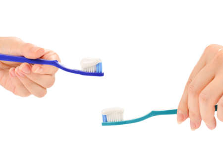 Woman holds toothbrush with toothpaste in her hand isolated on white background.の写真素材