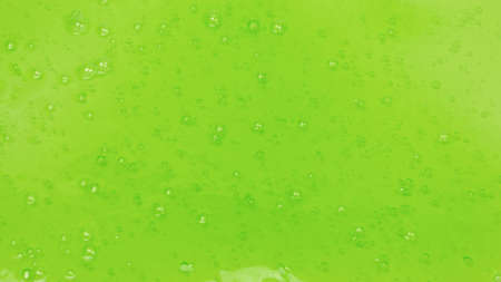 Green slime toy in woman hand isolated on white. Top view.
