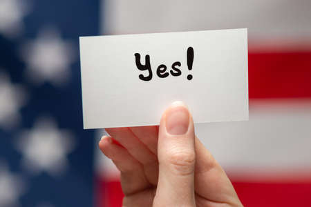 Yes text on a card. American flag background.の写真素材