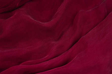 Soft smooth burgundy silk fabric background. Fabric texture.の写真素材