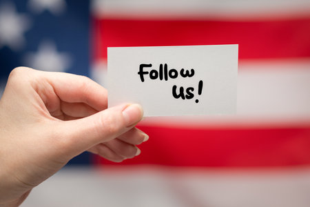 Follow us text on a card. American flag background.の写真素材