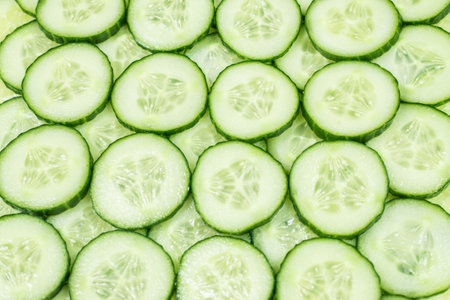 Fresh green slices of cucumber as background. Top view.の写真素材