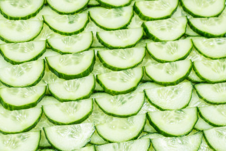 Fresh green slices of cucumber as background. Top view.の写真素材