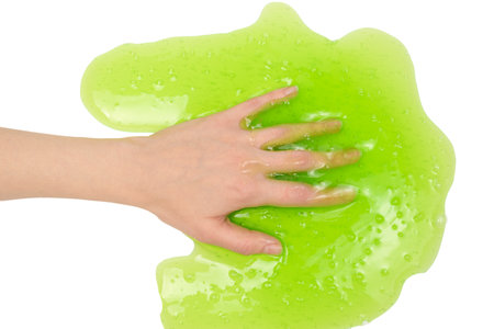 Green slime toy in woman hand isolated on white background.の写真素材