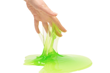 Green slime toy in woman hand isolated on white background.