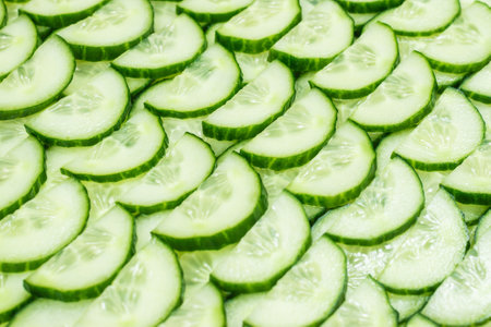 Fresh green slices of cucumber as background. Top view.の写真素材