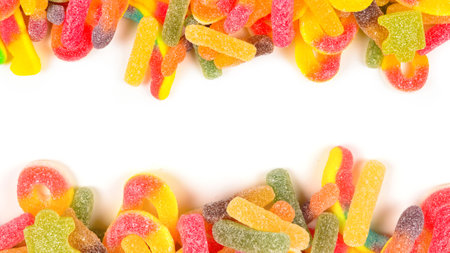 Frame of assorted gummy candies isolated on white. Top view. Space for text or design.