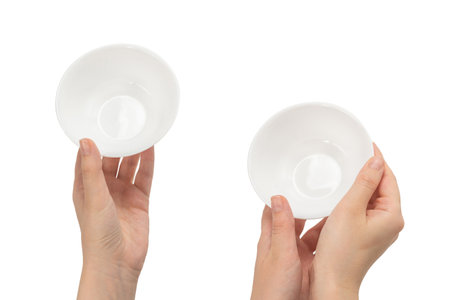 White bowl in woman hand isolated on white background.の写真素材